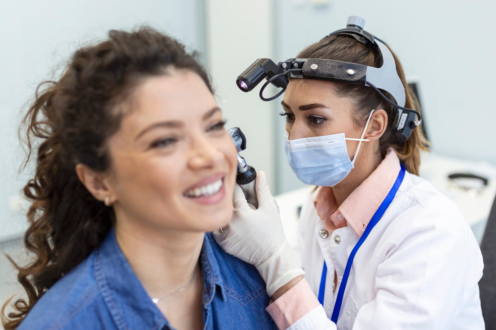 ENT specialist examining a patient's ear with an otoscope