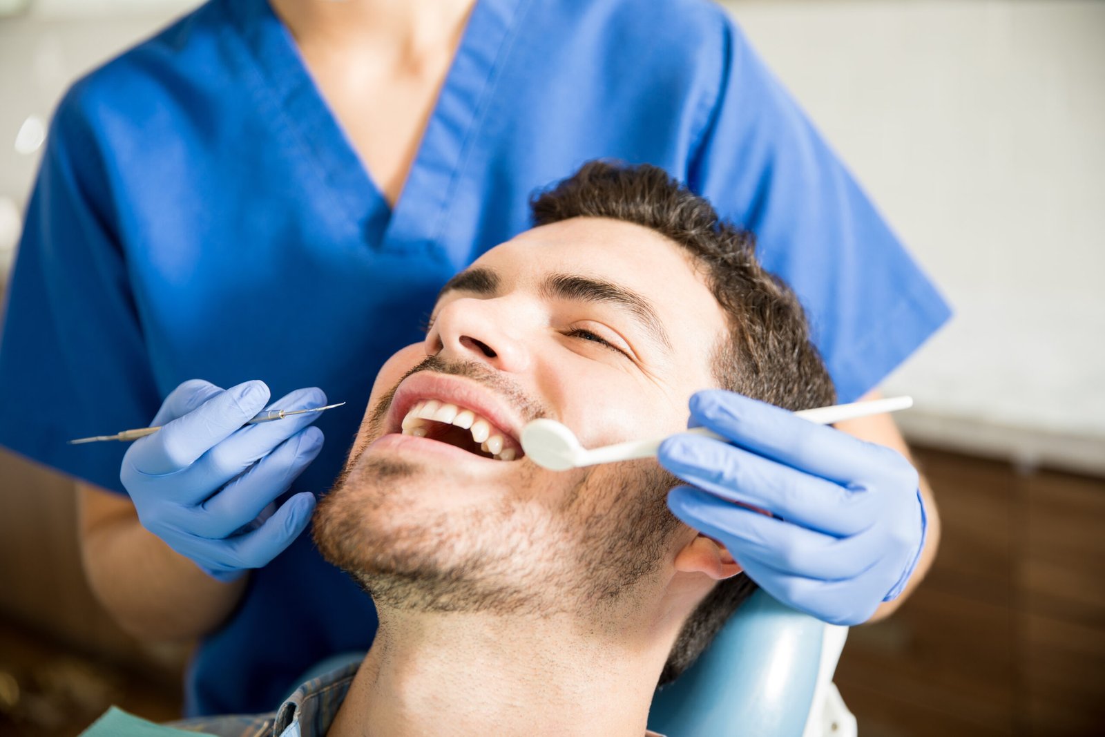 Dentist examining an adult patient's teeth in a dental clinic