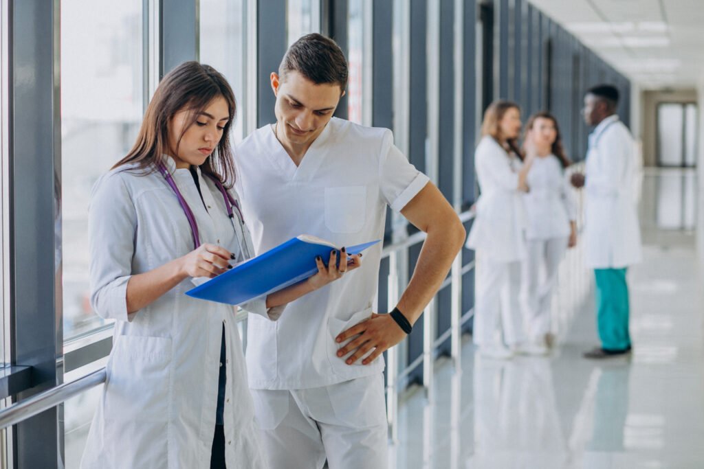 Two healthcare professionals reviewing patient information in a hospital corridor