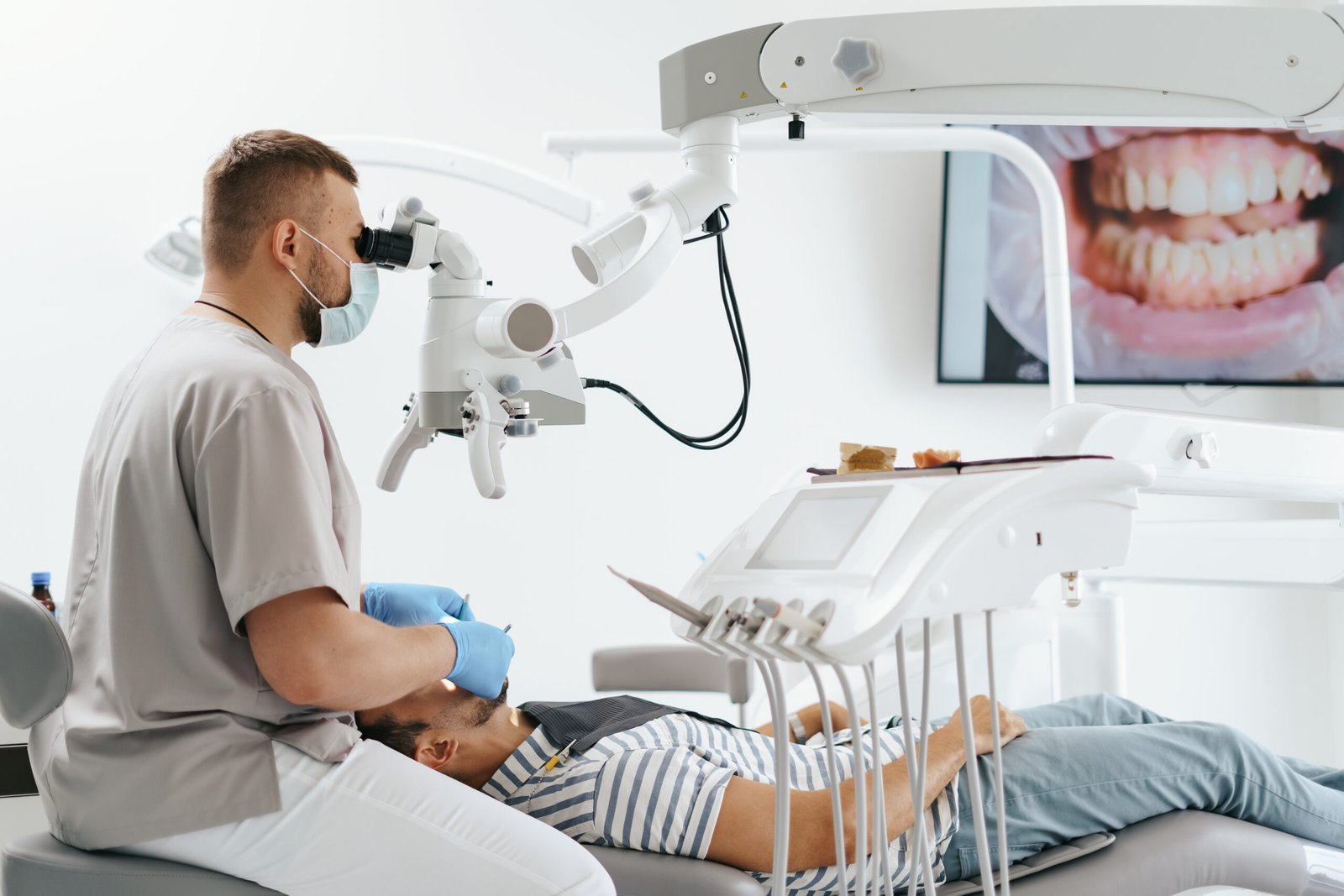 Dentist using a clinical microscope during dental treatment