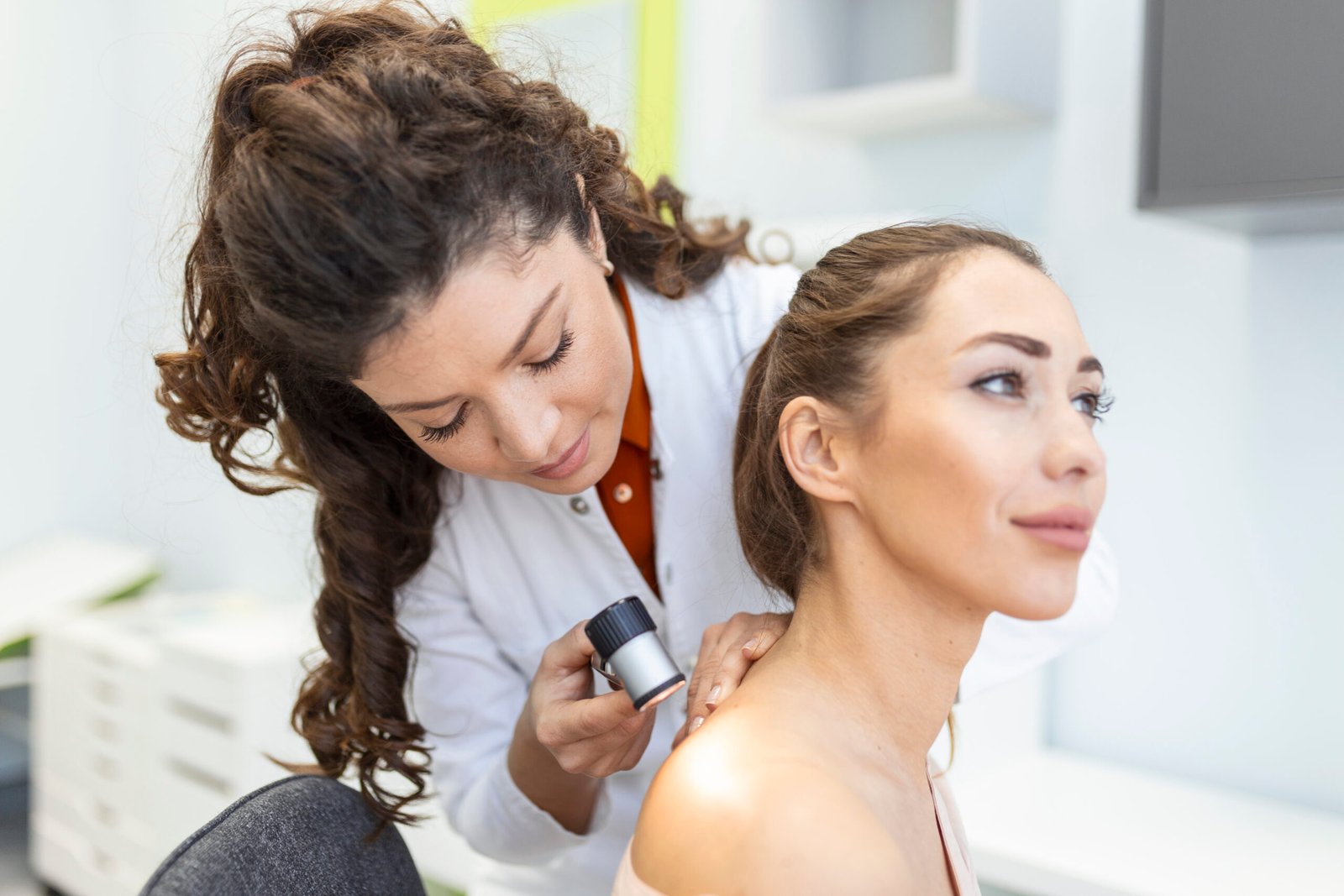Dermatologist examining a patient's skin with a dermatoscope