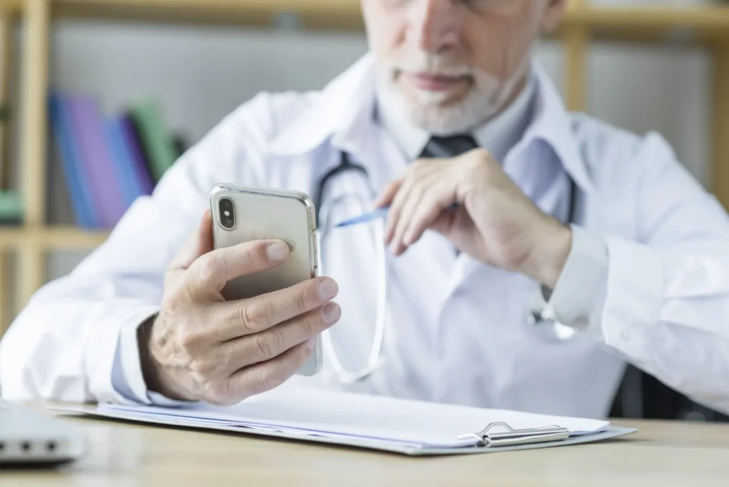 Doctor using a smartphone at a desk.